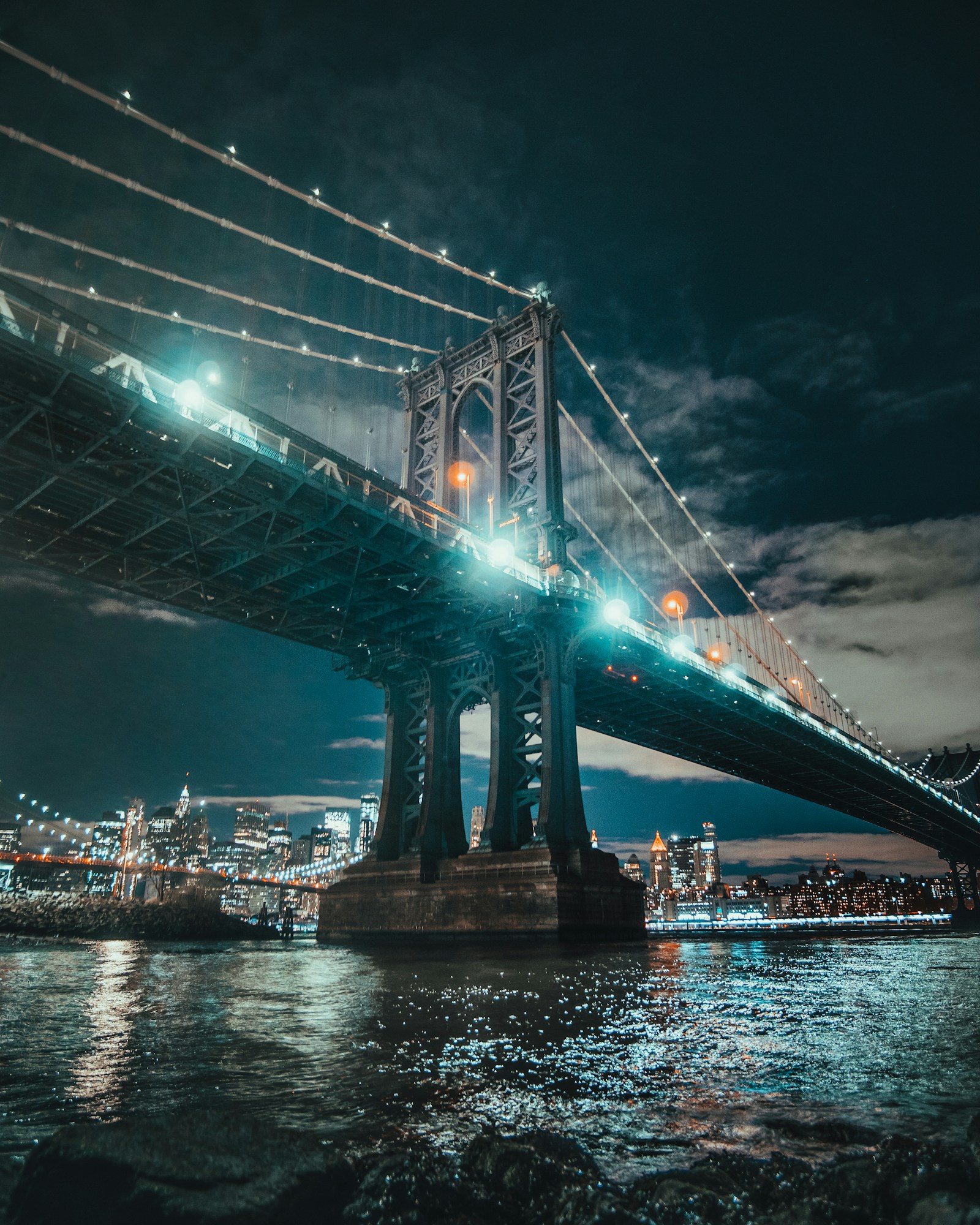 Manhattan Bridge illuminated above the East River at night